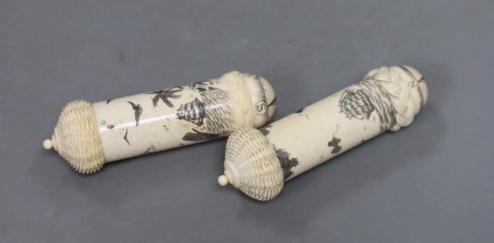 Two bone scrimshaw needle cases, 12cms high